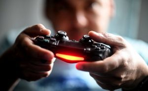 02 April 2020, Berlin: A young man plays in front of the television with the Playstation game console. To prevent infection with the corona virus, many people spend their free time at home. Photo: Britta Pedersen/dpa-Zentralbild/dpa (Photo by Britta Pedersen/picture alliance via Getty Images)